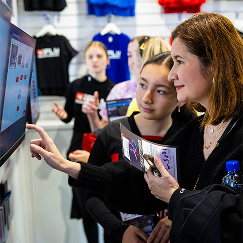Visitors using an iFLY touchscreen kiosk together