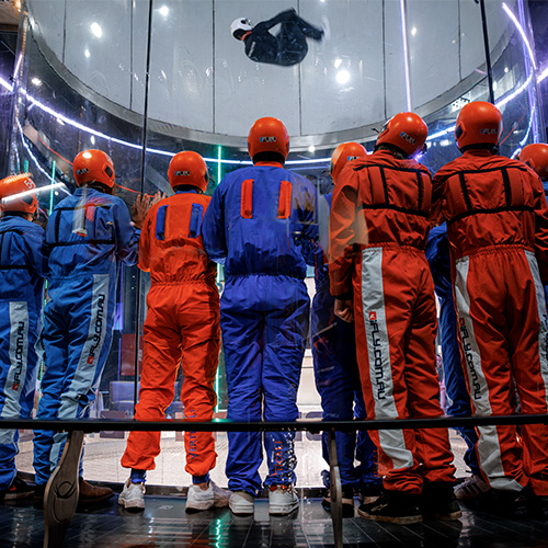A group of flyers watching an instructor flying in the wind tunnel