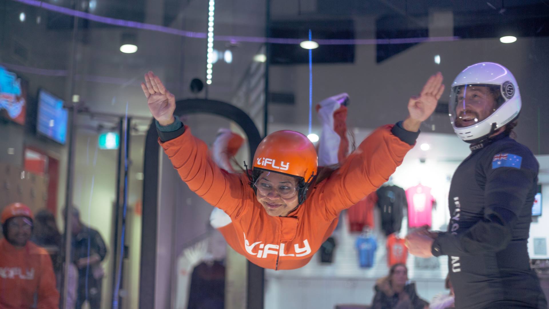 Lady in orange jumpsuit flying with instructor.